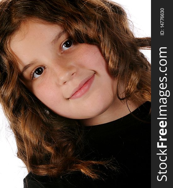 Closeup portrait of a happy, young preteen in ringletts.