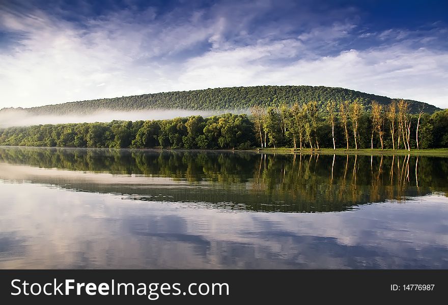 In a river landscape with nature morning with fog