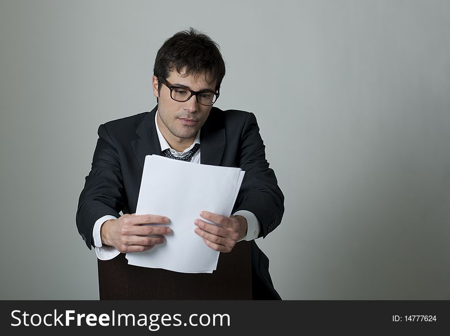 Businessman reading document, isolated on grey