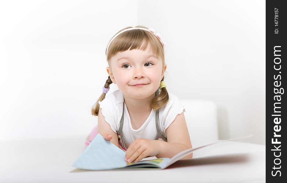 Sweet happy little girl reading book