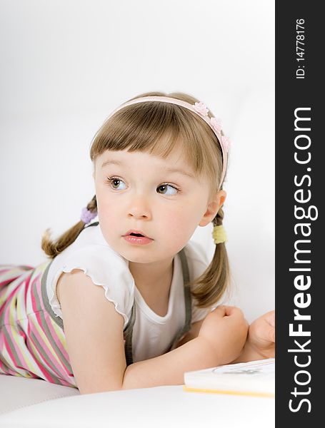 Sweet happy little girl reading book