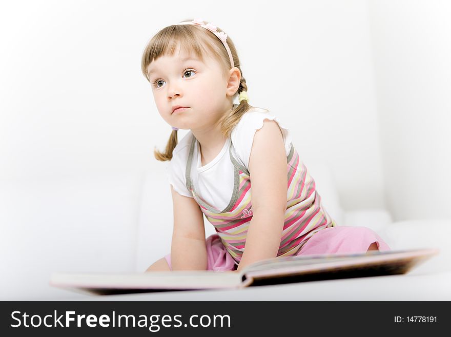 Sweet happy little girl reading book