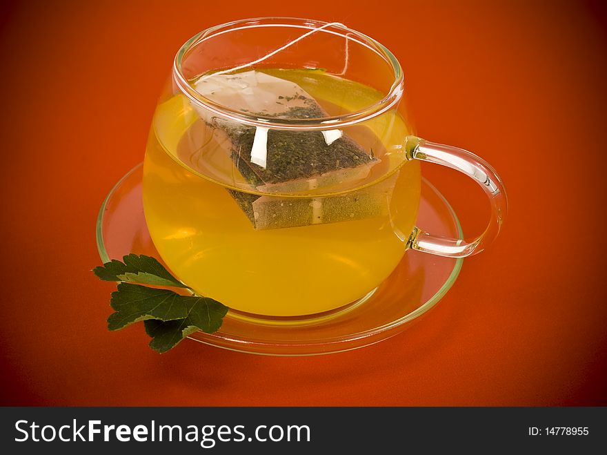 Transparent tea cup on red background