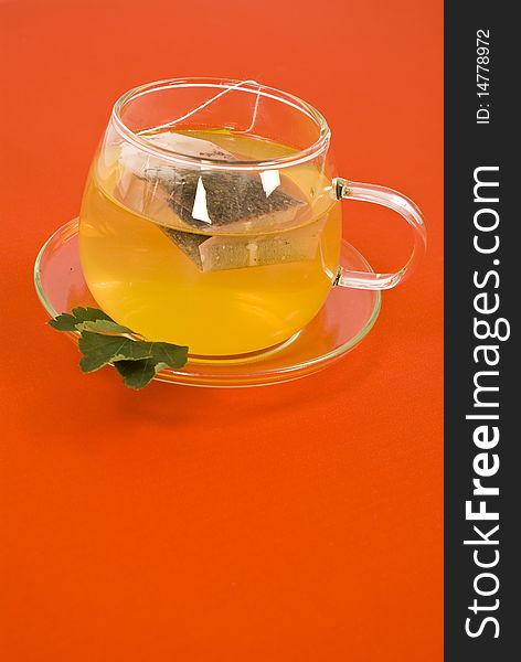 Transparent tea cup on red background