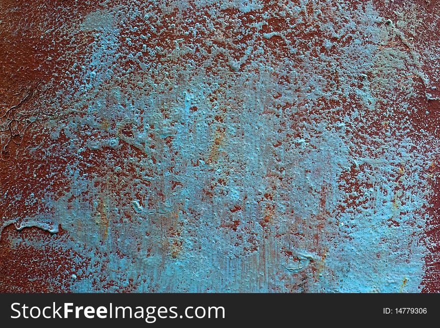 The surface of the painted metal. The lower layer is in warm tones of brown color, the upper layer in the cold tones of blue light