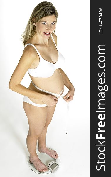 Pregnant woman standing on weight scale