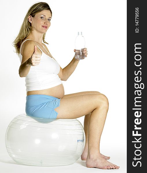 Pregnant woman doing exercises with a bottle of  water