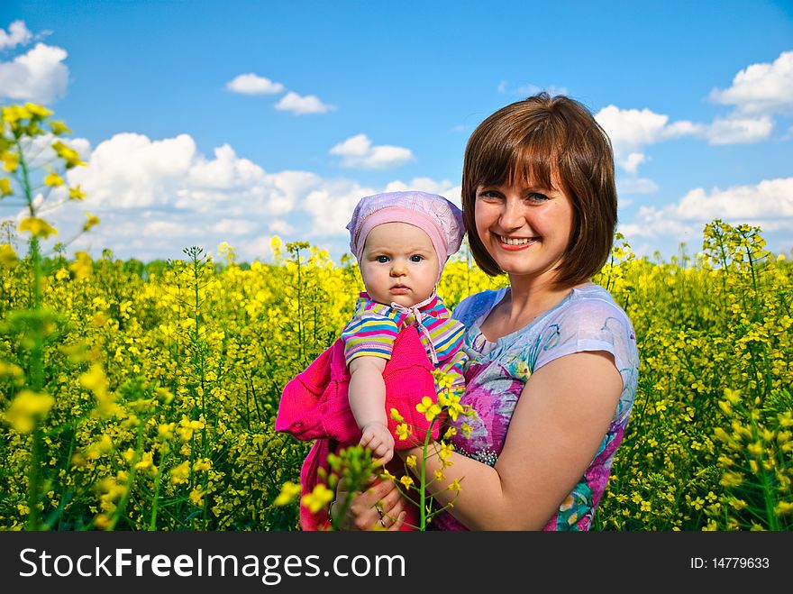 Happy young mother with baby at spring field flowers. Happy young mother with baby at spring field flowers