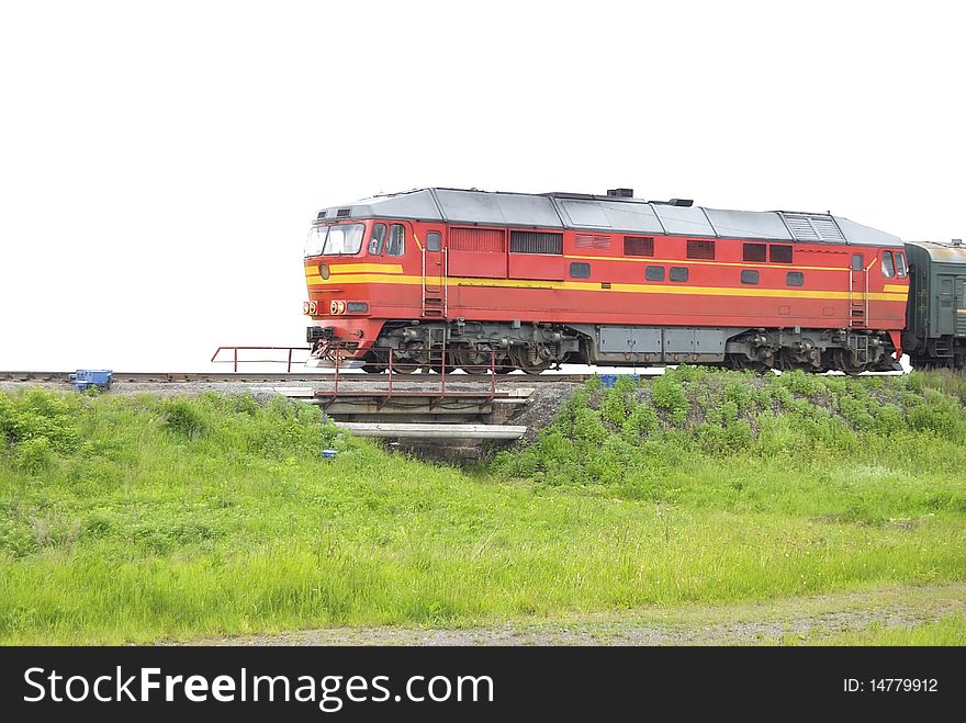 The red locomotive pulls passenger wagons. Isolated on white background. The red locomotive pulls passenger wagons. Isolated on white background