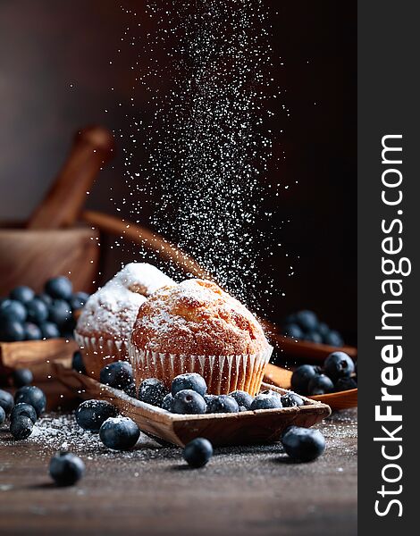 Muffins and blueberries sprinkled with powdered sugar