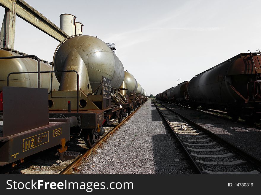 Railway and rusty wagons and grey sky above. Railway and rusty wagons and grey sky above