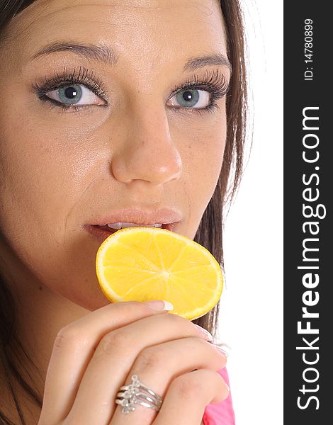 Model eating an orange slice upclose