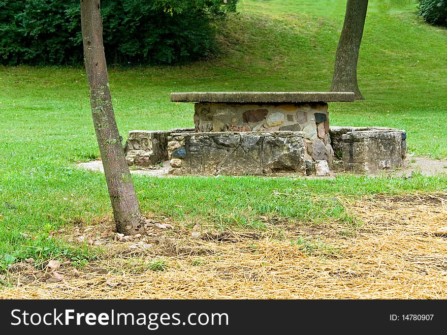 A picnic table on a slopping lawn with straw over newly sown grass. A picnic table on a slopping lawn with straw over newly sown grass.