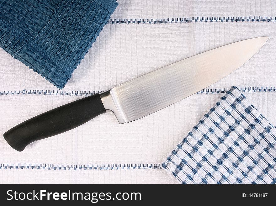 Kitchen professional knife in an environment of napkins from a fabric. Kitchen professional knife in an environment of napkins from a fabric.