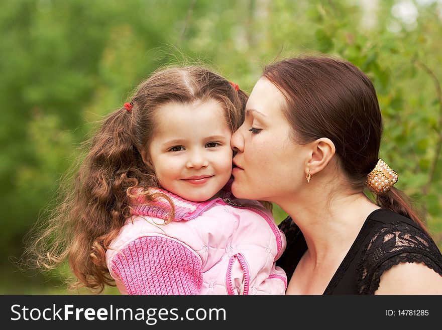 Mum kisses the small daughter. Mum kisses the small daughter