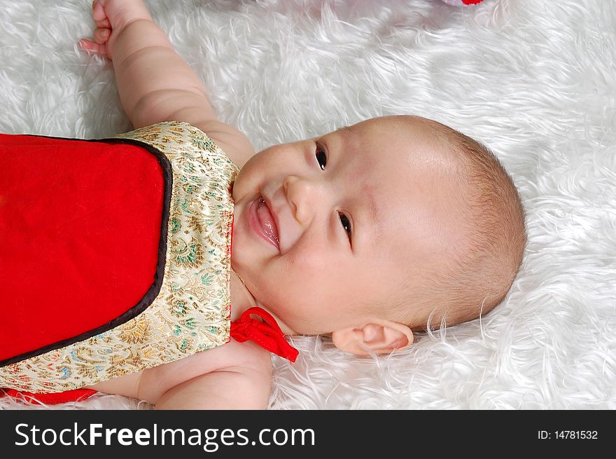 The Chinese infant baby boy lying on white feather. The Chinese infant baby boy lying on white feather