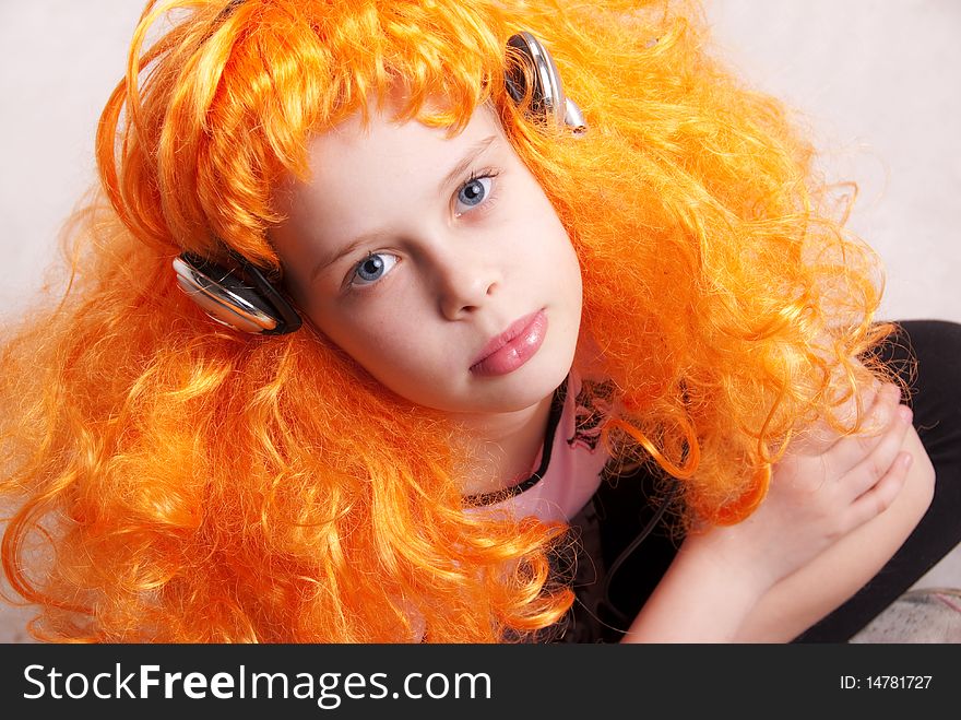 Beautiful little redheaded girl / child listening to disco music with headphones against white background, closeup studio portrait. Beautiful little redheaded girl / child listening to disco music with headphones against white background, closeup studio portrait