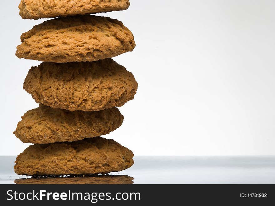 Stack of oaten cookies on reflective surface
