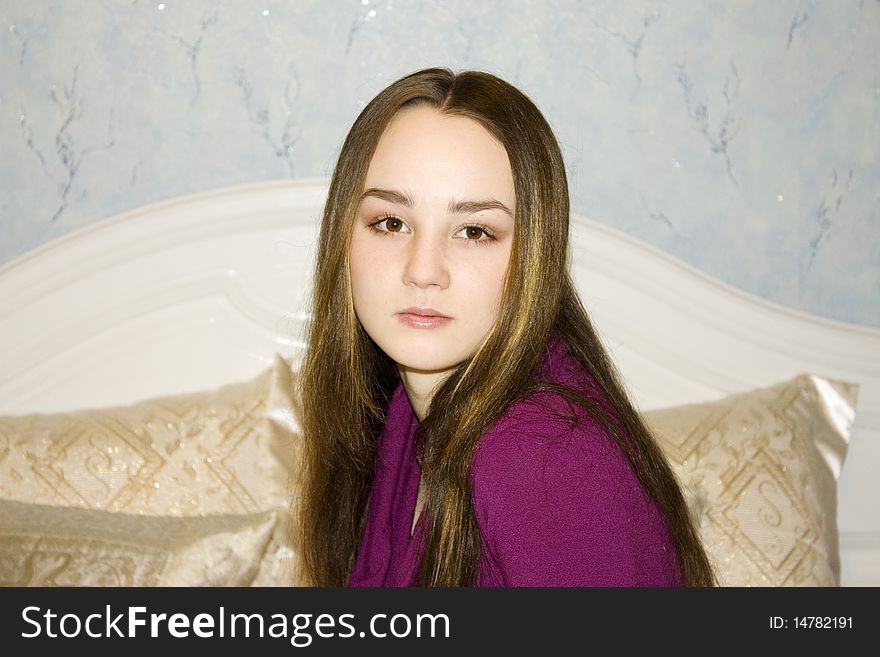 Portrait of beautiful girl sitting on bed