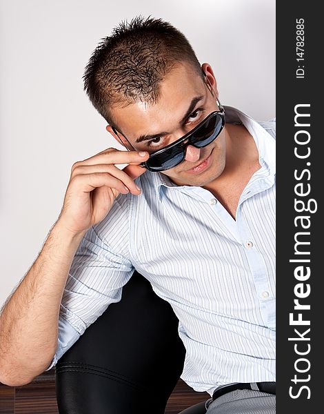 Young man with sunglasses sitting on an armchair