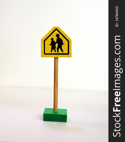 A yellow and black pedestrian crossing road sign isolated on a white background.