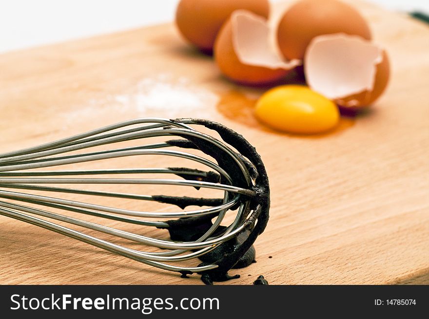 Spatula used in mixing a bowl of chocolate cake mix along with the fresh eggs are featured. Spatula used in mixing a bowl of chocolate cake mix along with the fresh eggs are featured.