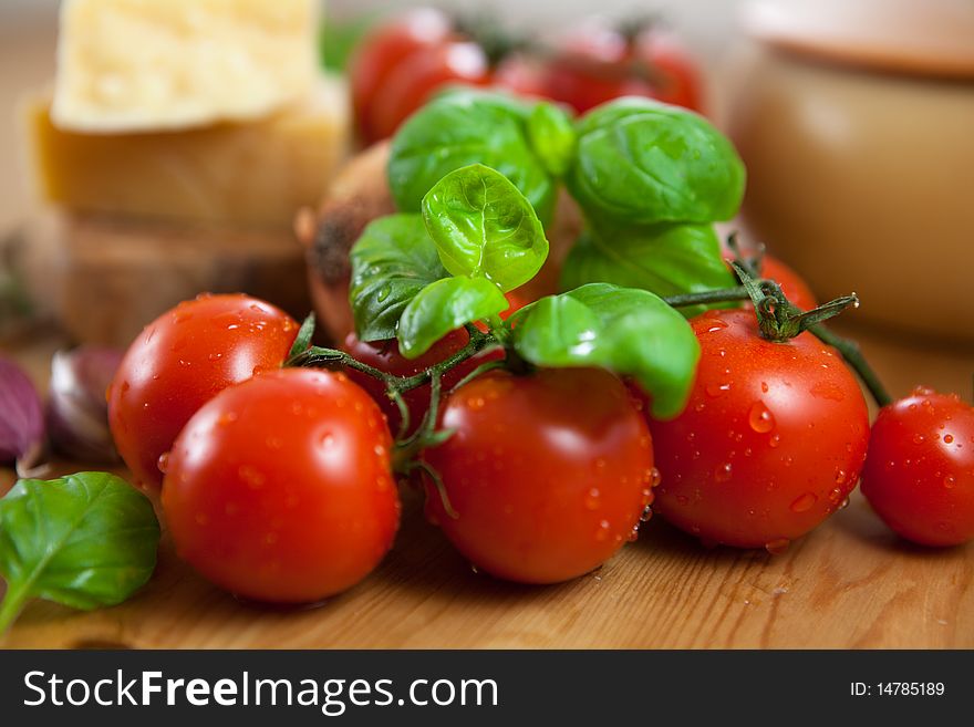 Close-up of fresh cherry tomatoes and basil on rustic wooden table