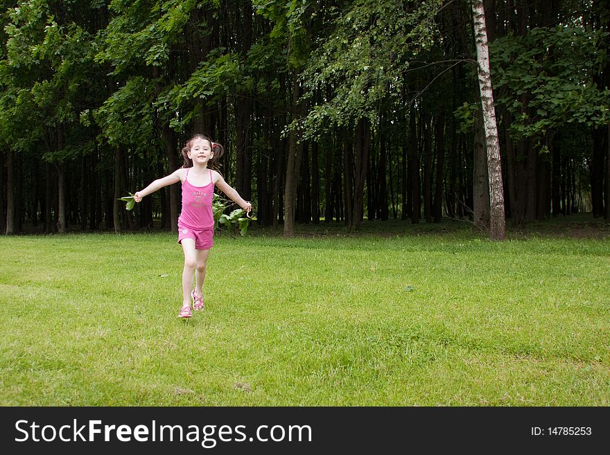 Little girl running in a park in summer. Little girl running in a park in summer.