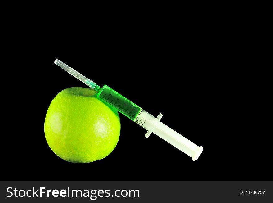 Syringe and green apple on black background. Syringe and green apple on black background