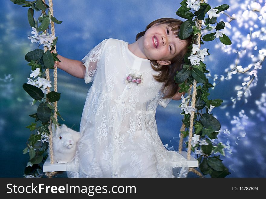 Small girl enjoys being on swing with flowers. Small girl enjoys being on swing with flowers