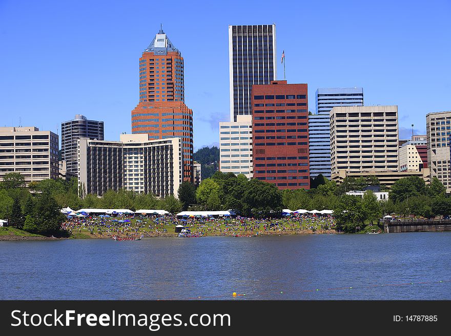 Crowds are gathered  at a river front festival for the annual Dragon boat races and other miscellaneous activities. Crowds are gathered  at a river front festival for the annual Dragon boat races and other miscellaneous activities.