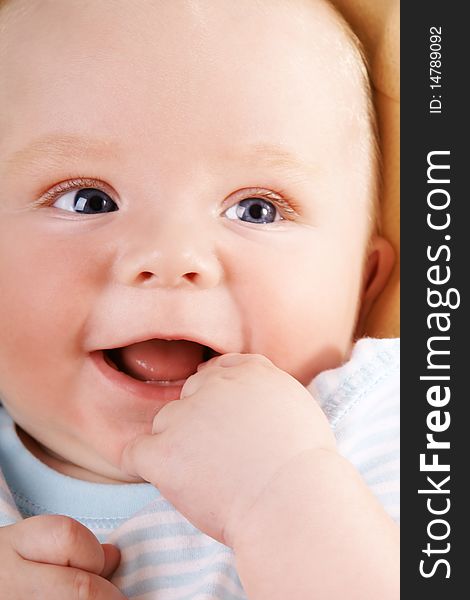 Portrait of happy laughing baby-boy with blue eyes, studio shot