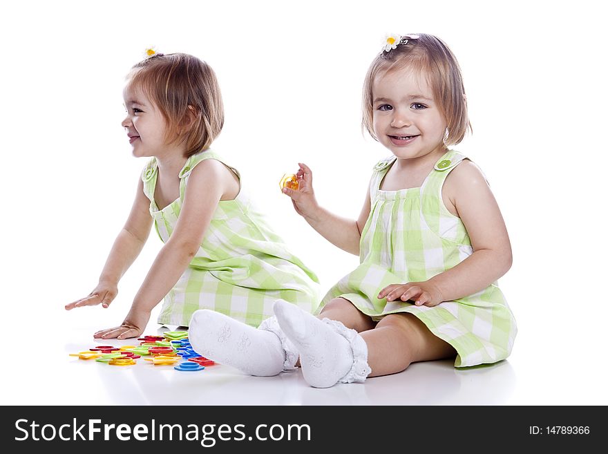 Small children play with toys on white background