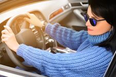 Free A Beautiful Pretty Brunette Woman In A Blue Sweater And Sunglasses Is Driving A Car. Toned Royalty Free Stock Photos - 147835838