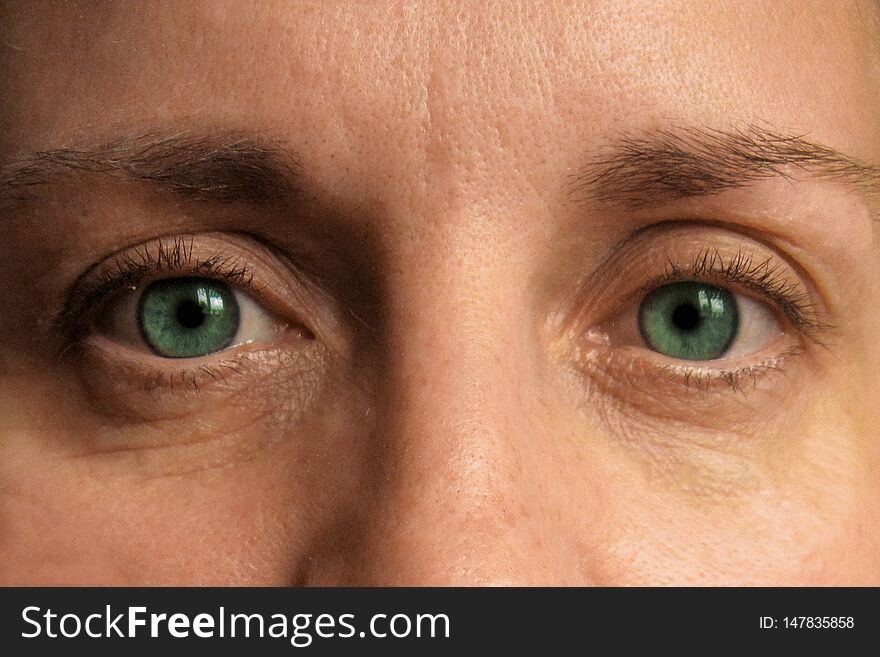Closeup of middle aged woman eyes. Real  face without make up and correction. Look at camera