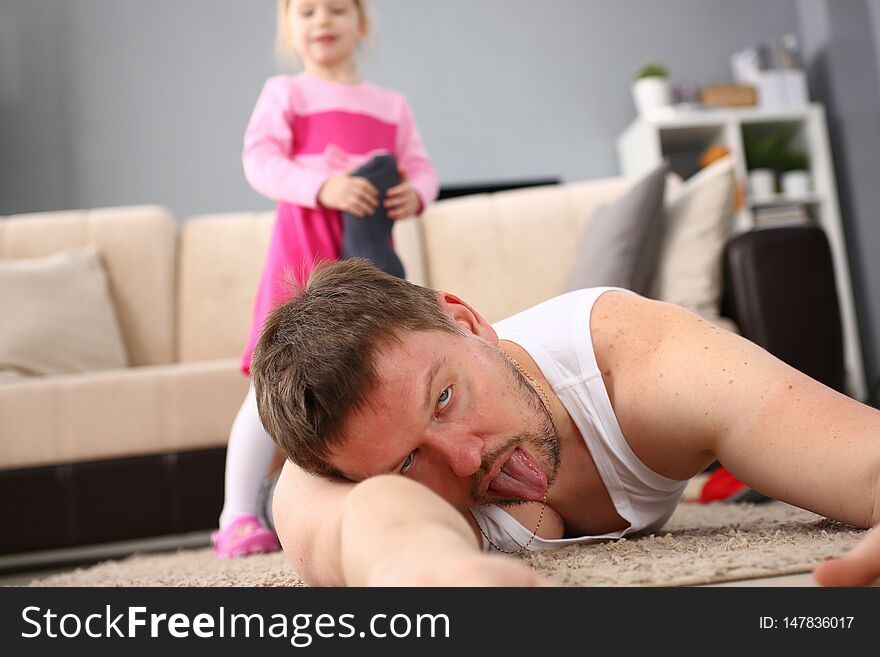 Cute little girl hold her father leg as proof of winning battle game