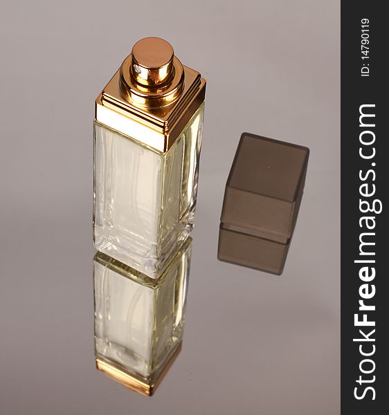 Bottle of perfume with mirror reflection.