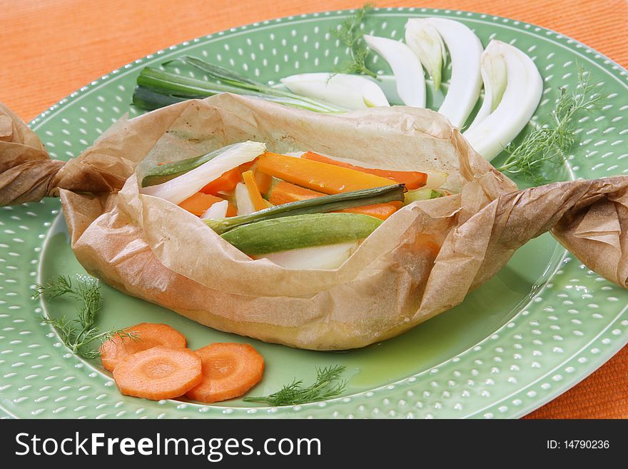 Delicious cooked fish in paper with vegetables