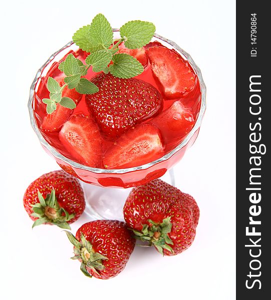 Jelly with strawberries decorated with a lemon balm twig and three strawberries