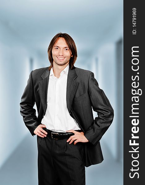 Young confident businessman standing in the corridor