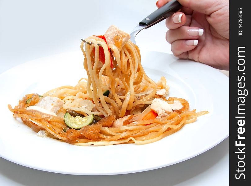 Chicken pasta dish with hand holding fork. Chicken pasta dish with hand holding fork