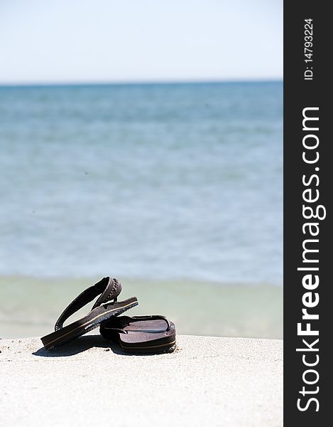 Beach landscape with flip flops on the sand