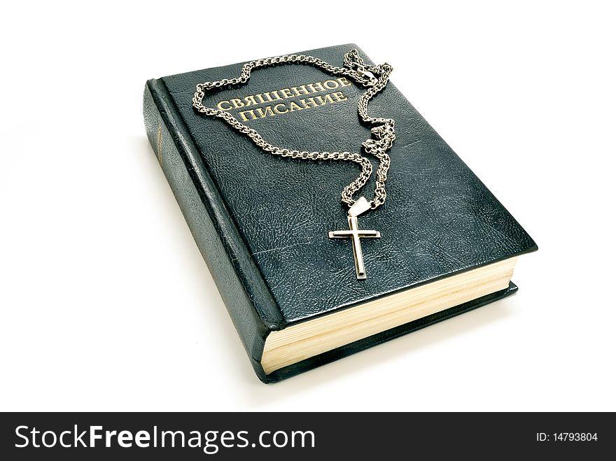 Book of the Bible and a silver cross and chain on white background