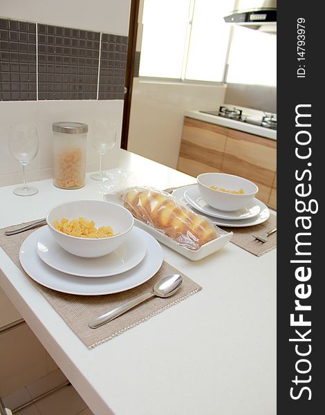 An image of a dinning table at a kitchen with breakfast served.