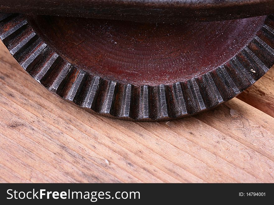 Old steel gear wheel on a wooden table. Old steel gear wheel on a wooden table.