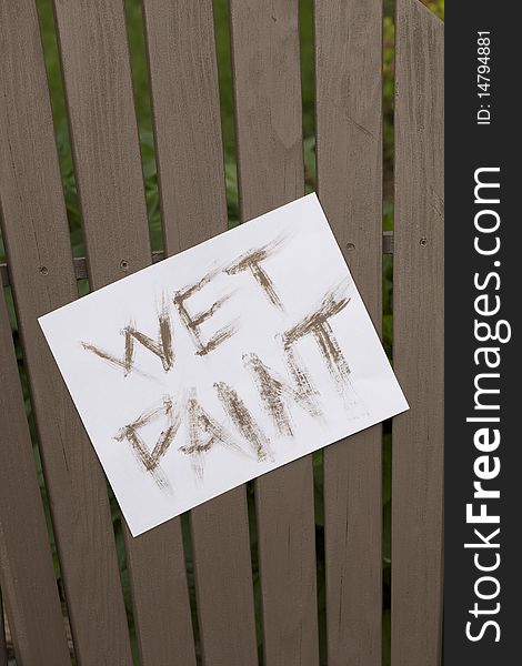 A wet paint sign on a freshly painted outdoor chair