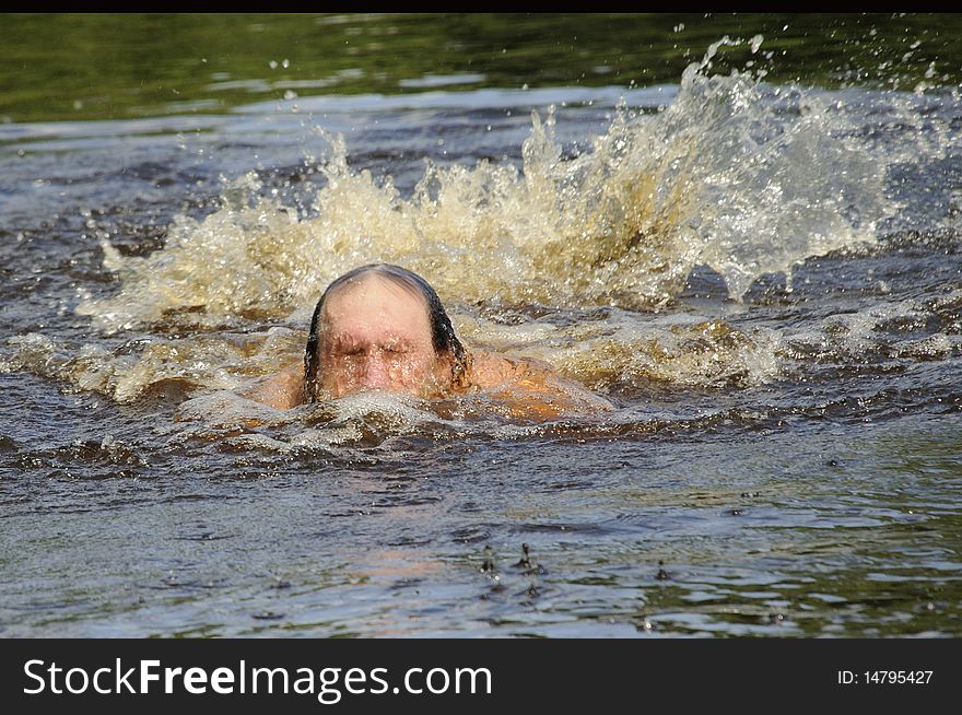 The elderly man floats butterfly stroke in open water. The elderly man floats butterfly stroke in open water