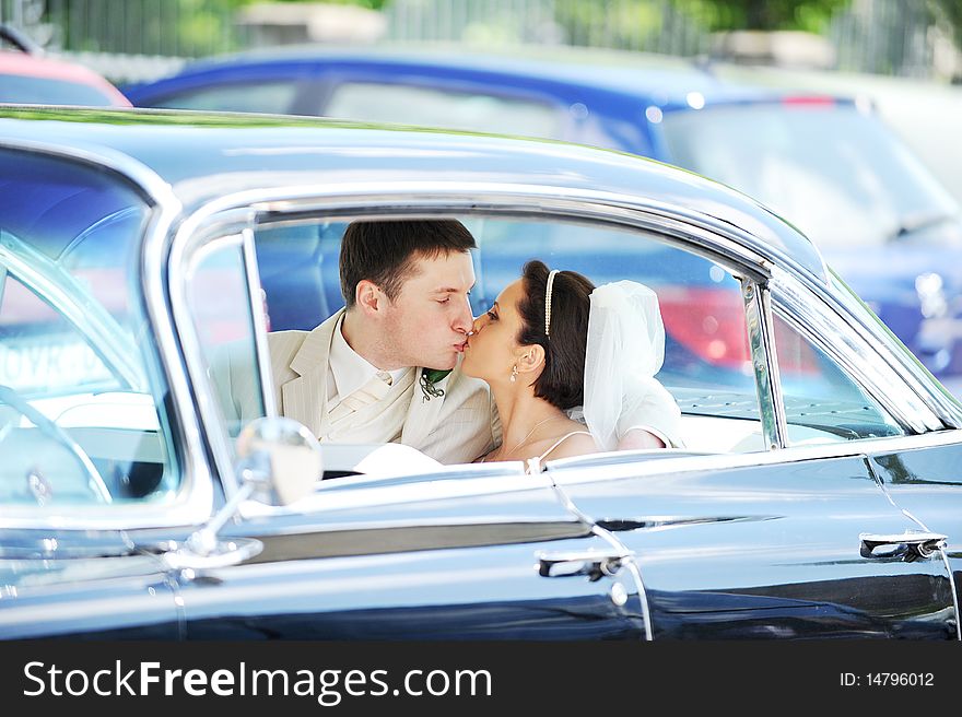 Newlywed couple, groom  and bride,  kissing in car. Newlywed couple, groom  and bride,  kissing in car