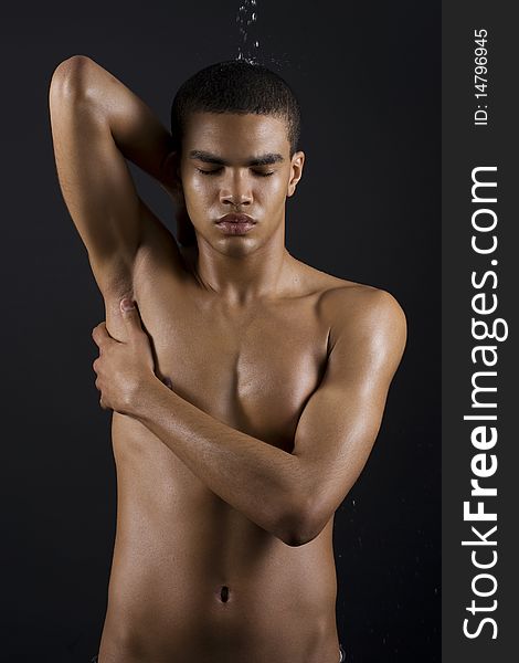 Drops of the water on naked body of a young man on black background. Drops of the water on naked body of a young man on black background.