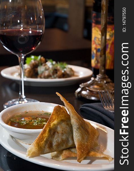 Pot stickers with dipping sauce and wine